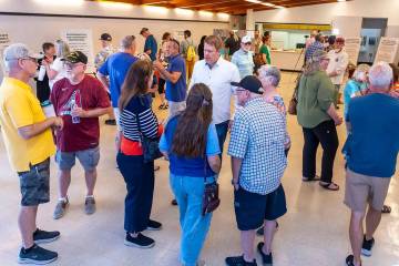 Residents and other concerned citizens talk to each other and look at information boards during ...