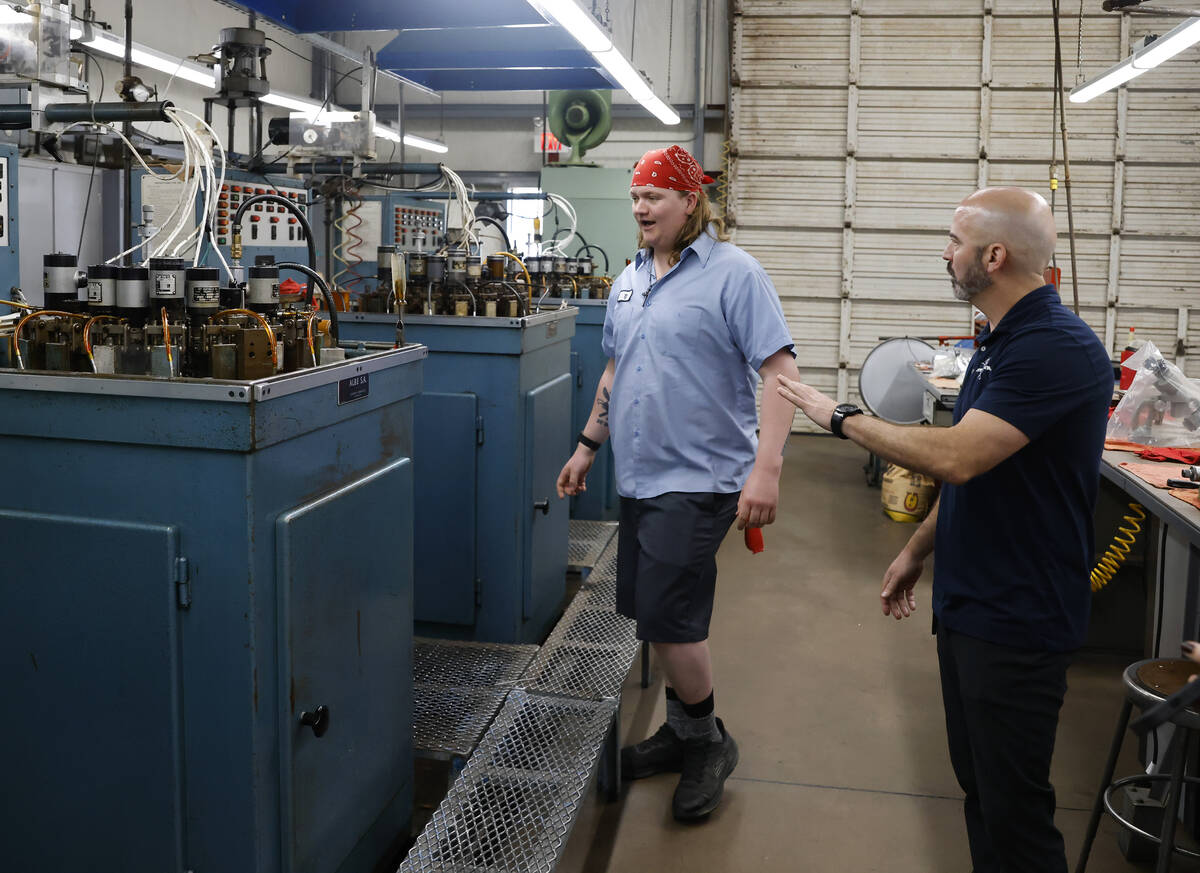 Matt Fisher, VP of Fisher Space Pen, right, talks to TJ Rowe, a machine operator, as he leads a ...