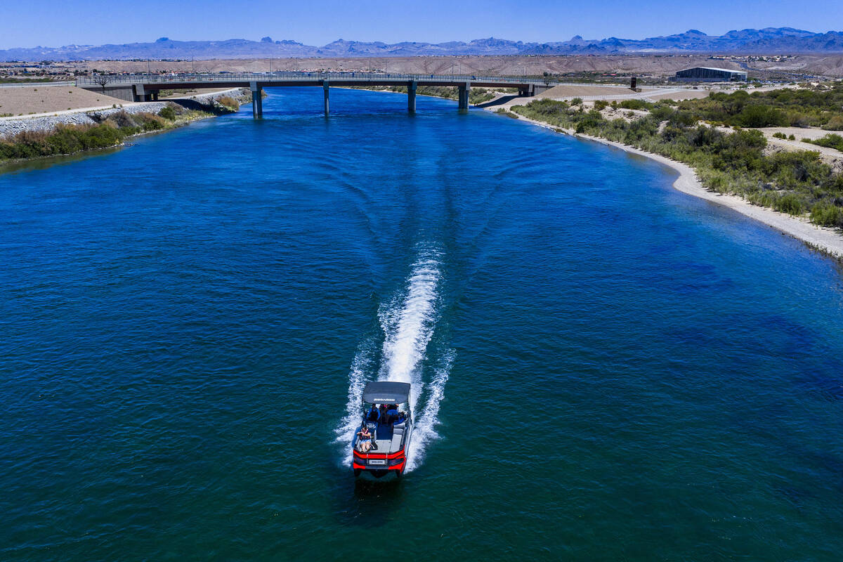 A boater moves along the Colorado River south of the new Silver Copper Crossing bridge on Frida ...