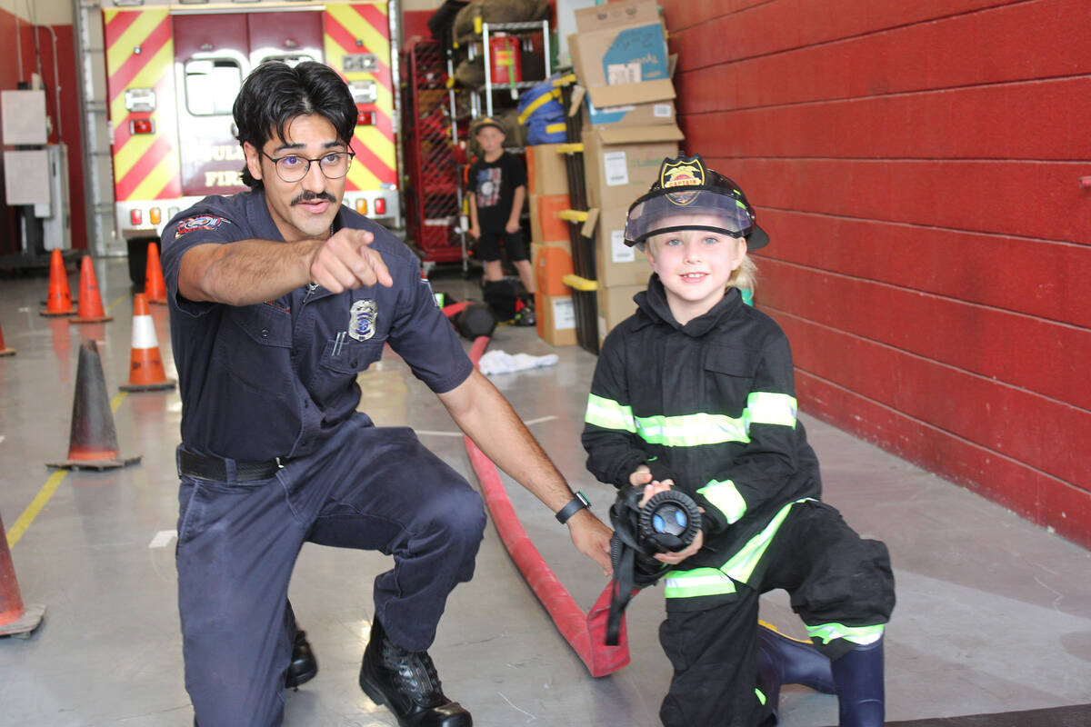 Ron Eland/Boulder City Review Boulder City Fire Department recruit Eric Benitez assists 7-year- ...